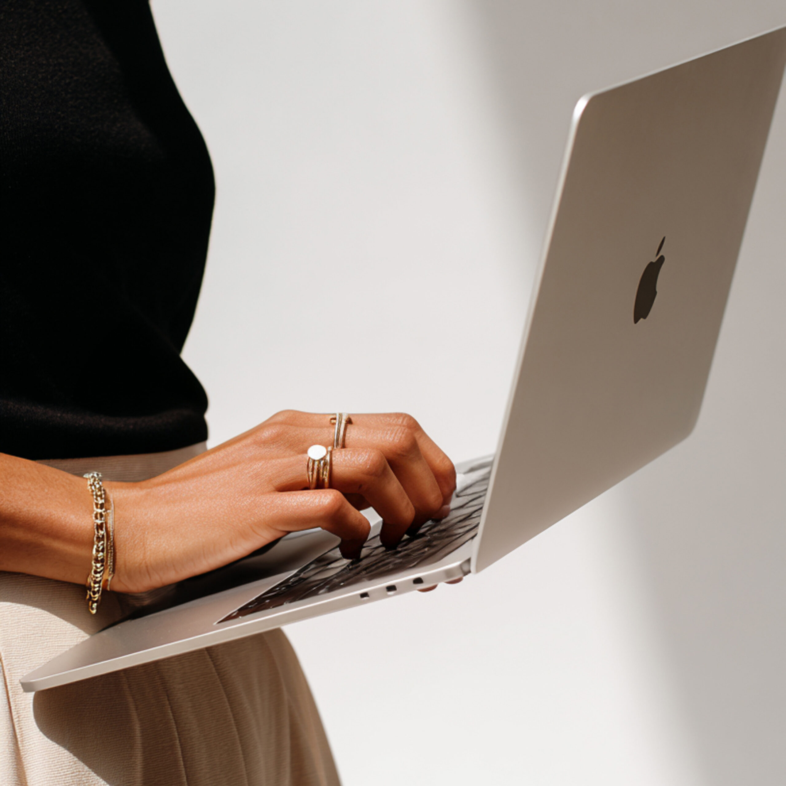 Close-up van een vrouw die een opengeklapte laptop vasthoudt | Elena & Company
